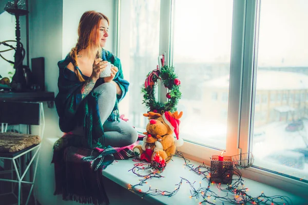 크리스마스 장식으로 창에 앉아 여자 — 스톡 사진