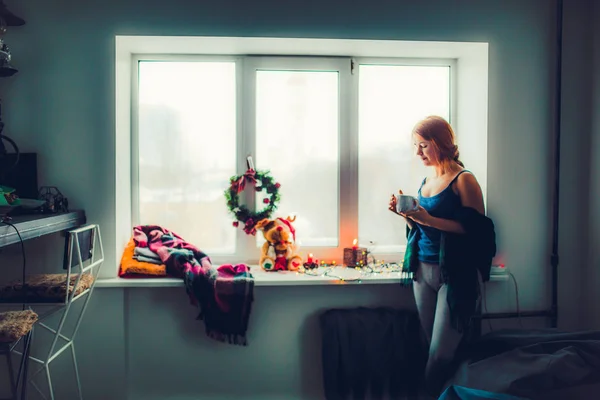 Menina de pé perto da janela com decoração de Natal — Fotografia de Stock