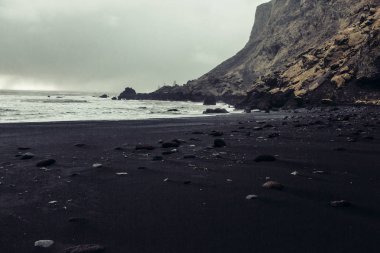 Siyah kum ve taş ile deniz kıyısı