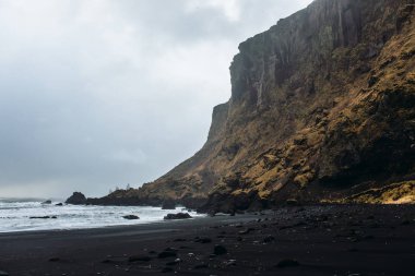 Siyah kum ve taş ile deniz kıyısı