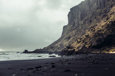 Siyah kum ve taş ile deniz kıyısı