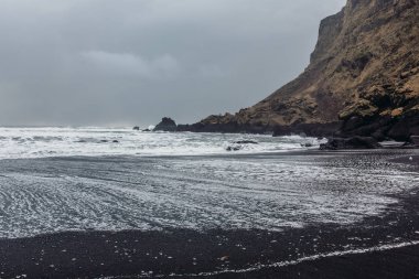 Siyah kum ve taş ile deniz kıyısı