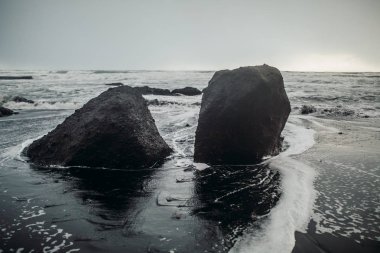 Siyah kum ve taş ile deniz kıyısı