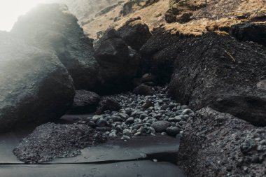 Siyah kum ve taş ile deniz kıyısı