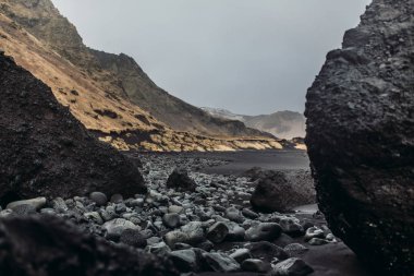 Siyah kum ve taş ile deniz kıyısı
