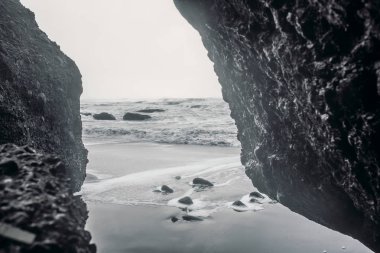 Siyah kum ve taş ile deniz kıyısı