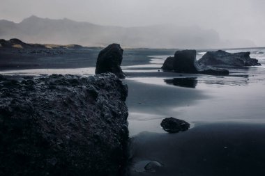Siyah kum ve taş ile deniz kıyısı