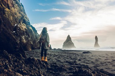 Kayalık sahil üzerinde duran genç kadın