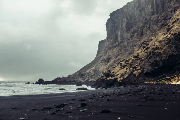 Mar com areia preta e pedras — Fotografia de Stock