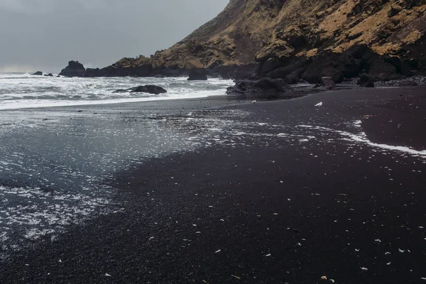 Costa con arena negra y piedras — Foto de Stock