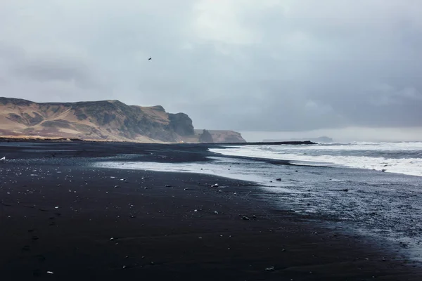 Seashore with black sand and stones — Stock Photo, Image