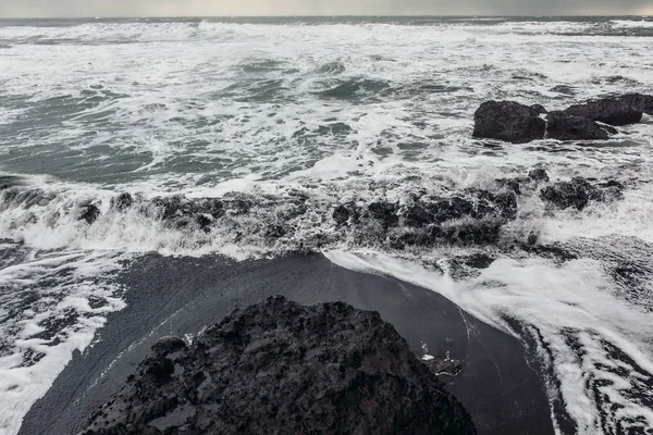 Stranden med svart sand och stenar — Stockfoto