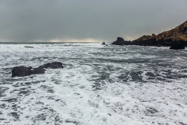 Kust met zwart zand en stenen — Stockfoto