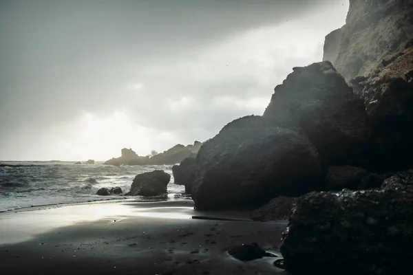 Stranden med svart sand och stenar — Stockfoto