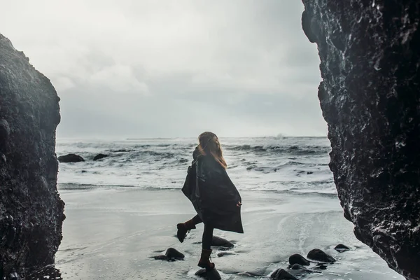 검은 모래 해변에 서 있는 여자 — 스톡 사진