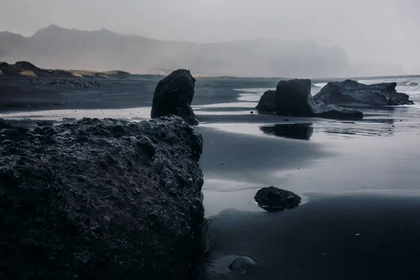 Stranden med svart sand och stenar — Stockfoto