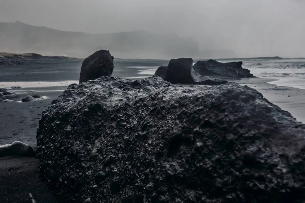 Kust met zwart zand en stenen — Stockfoto