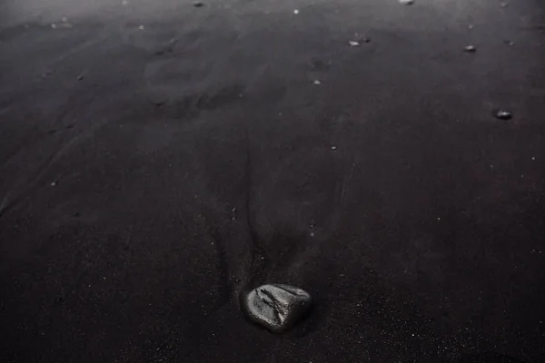 Küste mit schwarzem Sand und Steinen — Stockfoto
