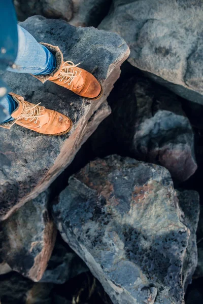 Πόδια σε μπότες που στέκεται πάνω σε πέτρες — Φωτογραφία Αρχείου
