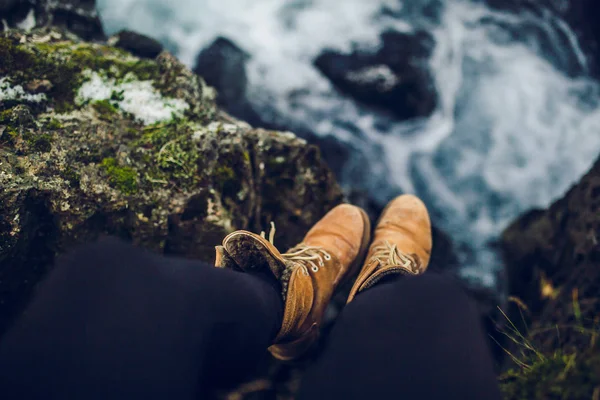 Legs in boots over water surface