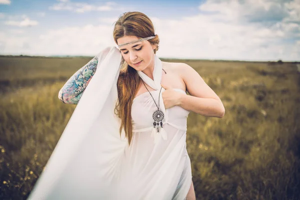 Vrouw in witte jurk in platteland veld — Stockfoto