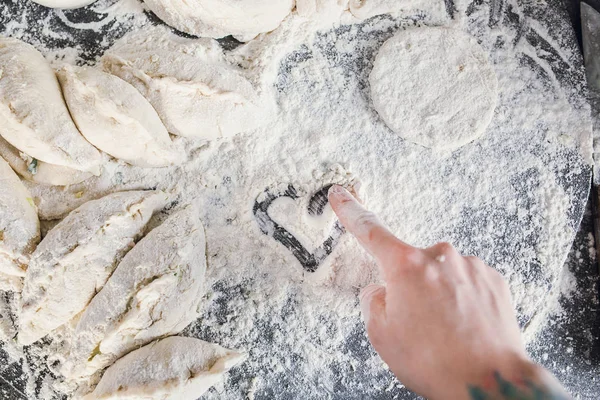 hand drawing heart on flour