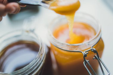 metal kaşık bal tutan el