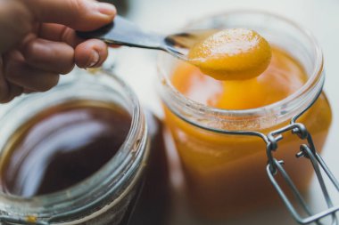 metal kaşık bal tutan el