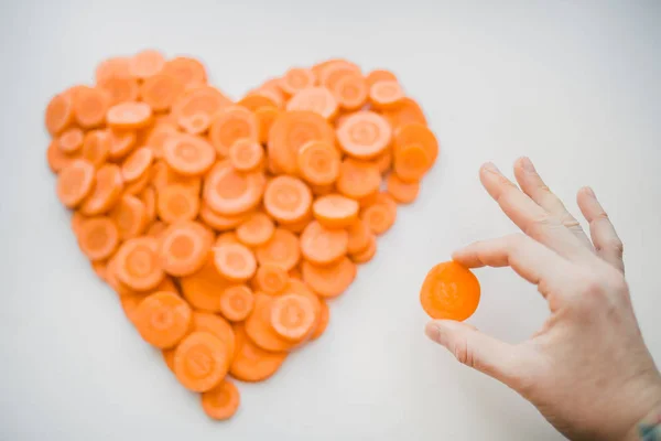 Tangan wanita membuat hati dari wortel — Stok Foto