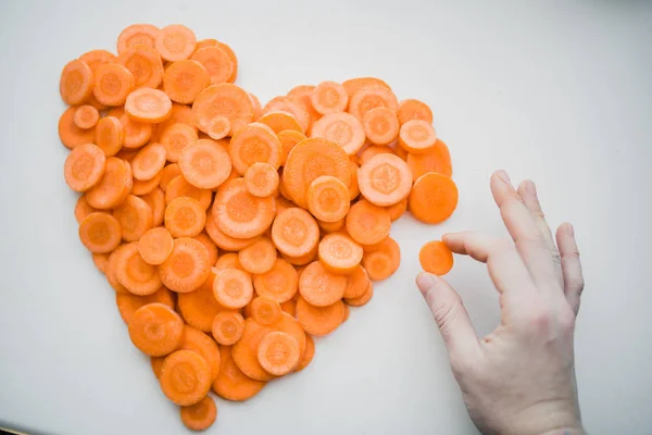 Tangan membuat jantung dari wortel — Stok Foto