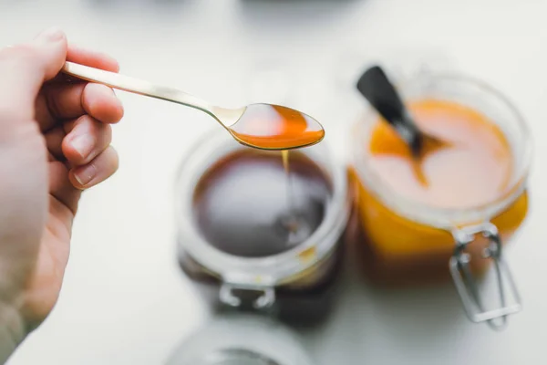 Рука держит ложку с сладким медом — стоковое фото