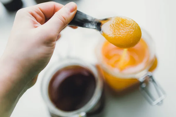 Hand holding spoon with sweet honey — Stock Photo, Image