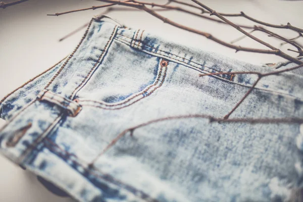 Blue jeans with tree branches — Stock Photo, Image