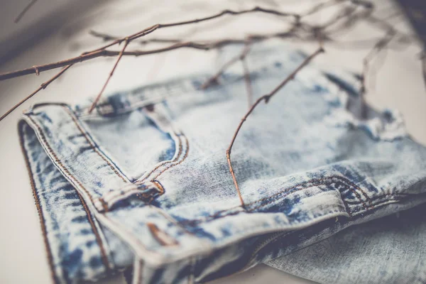 Blue jeans with tree branches — Stock Photo, Image