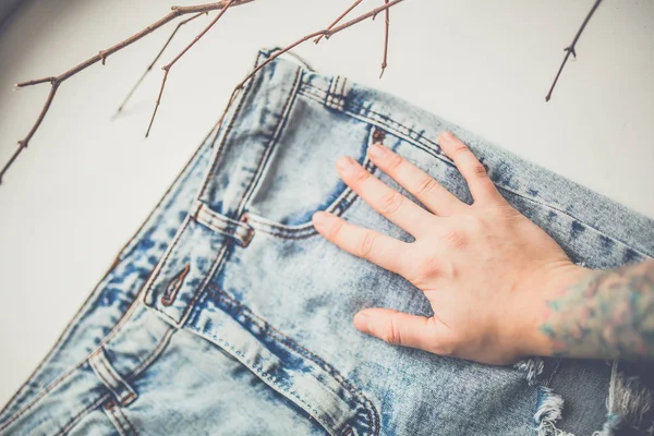 Female hand on blue jeans — Stock Photo, Image