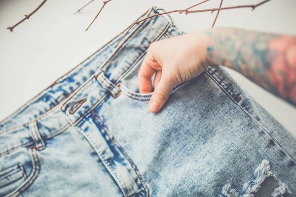 Weibliche Hand auf blauer Jeans — Stockfoto