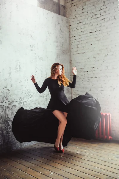Женщина танцует в черном платье — стоковое фото