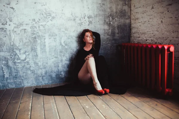 Vrouw in jurk en rode schoenen op verdieping — Stockfoto