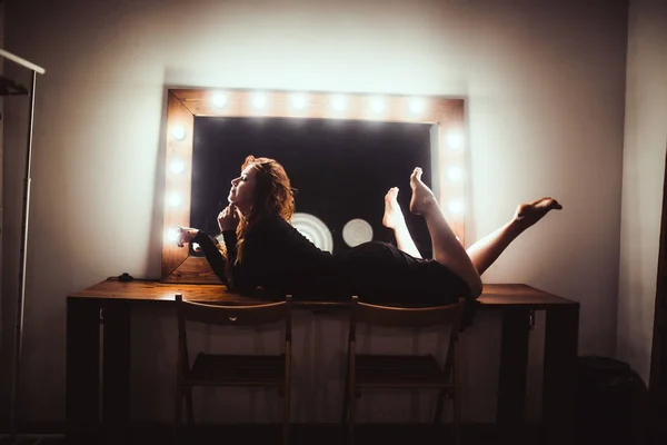 Mujer cerca del espejo con bombillas — Foto de Stock
