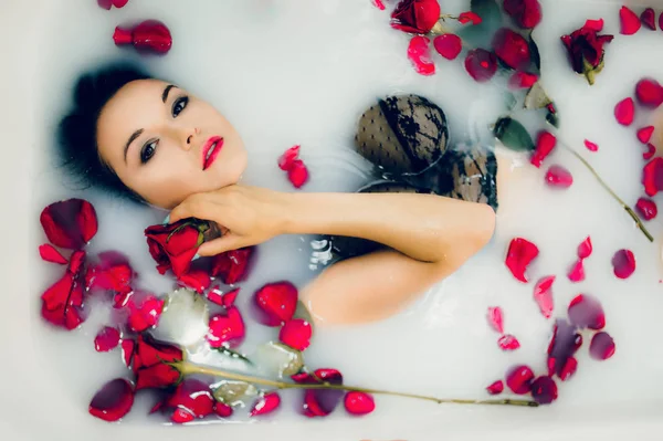 Femme en lingerie noire avec des roses — Photo