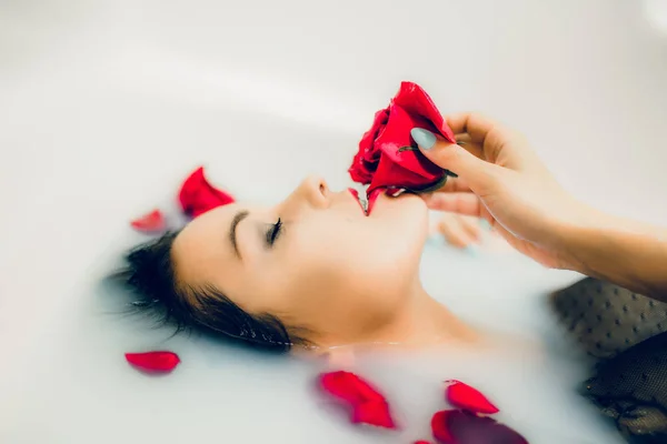 Vrouw met rode roos in badkamer — Stockfoto
