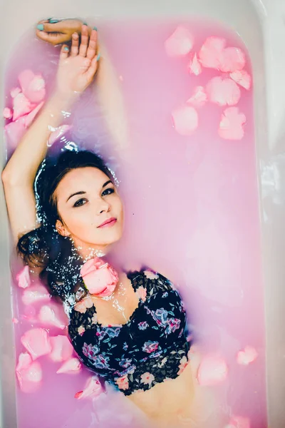 Nő a rózsaszín víz és a szirmok — Stock Fotó
