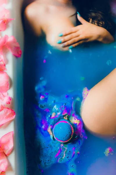 Mujer en agua azul y pétalos — Foto de Stock