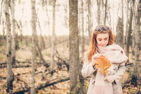 Redhead woman holding yellow leaf — Stock Photo, Image