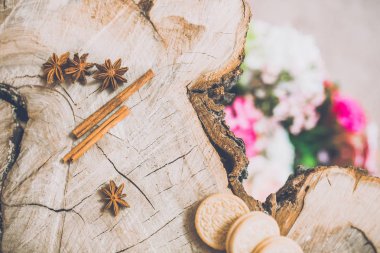 Anason yıldız ve tarçın ahşap masa üzerinde arka plan üzerinde bulanık çiçekli Close-Up 