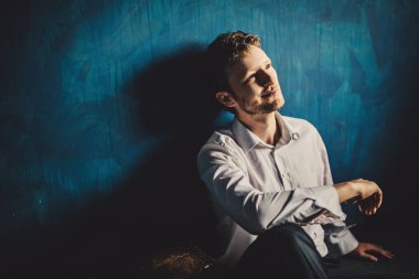 mavi duvar arka plan üzerinde genç yakışıklı işadamı portresi