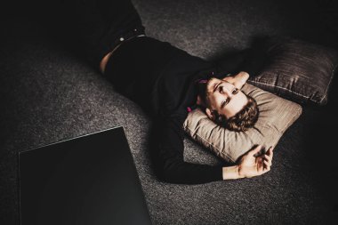 karanlık kat arka plan üzerinde yalan siyah giysili genç yakışıklı adam portresi