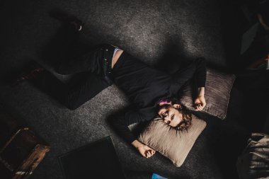 karanlık kat arka plan üzerinde yalan siyah giysili genç yakışıklı adam portresi