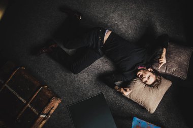 karanlık kat arka plan üzerinde yalan siyah giysili genç yakışıklı adam portresi