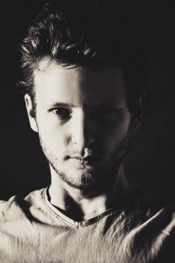koyu arka plan, siyah ve beyaz genç yakışıklı adam portresi 